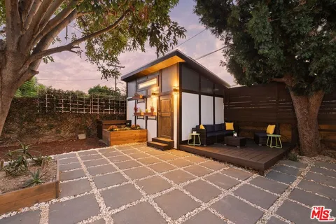 a view of a chairs and tables in the back yard of the house
