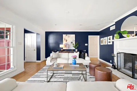 a living room with furniture a fireplace and a floor to ceiling window