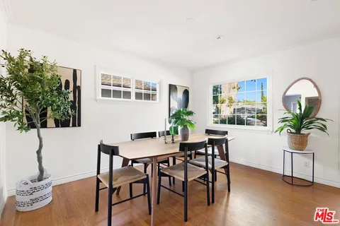 a view of a workspace room with wooden floor table and chair