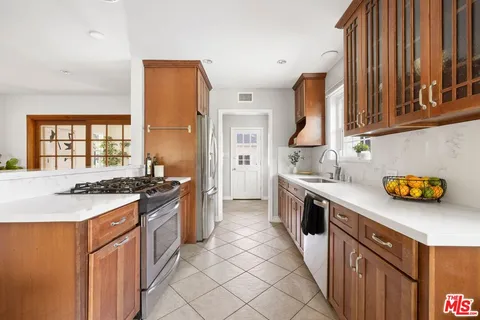a kitchen with stainless steel appliances a stove a sink and a refrigerator