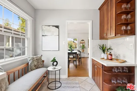 a dining room with furniture a potted plant and wooden floor