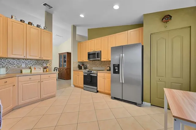 a view of a yard with plants and large trees