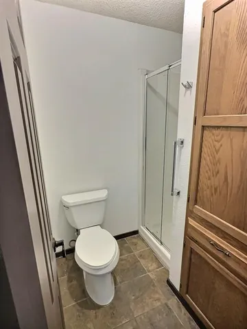 a bathroom with a toilet and a shower