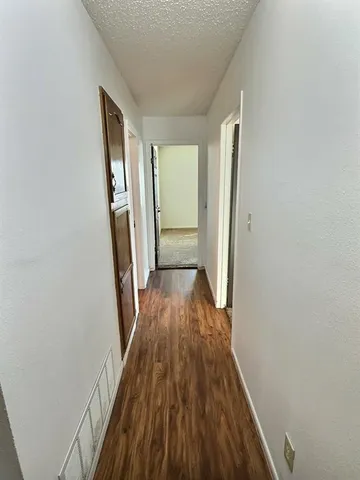 a view of a hallway with wooden floor