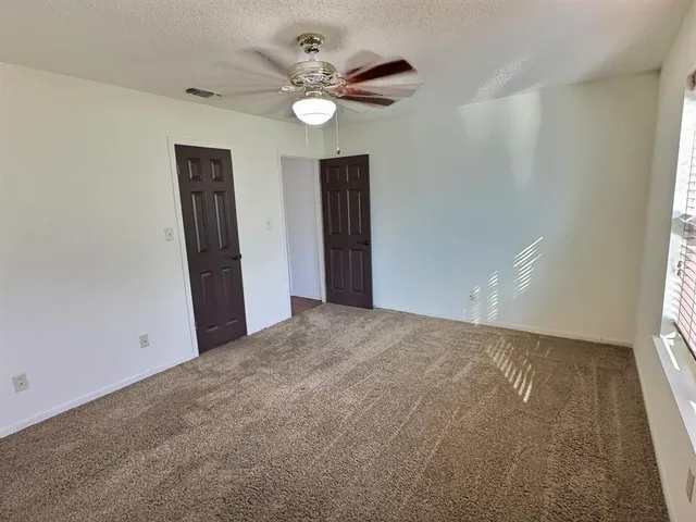 an empty room with closet and fan