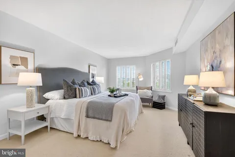 a bedroom with a bed window and dresser
