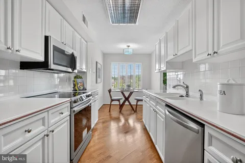 a kitchen with stainless steel appliances a sink stove top oven and cabinets