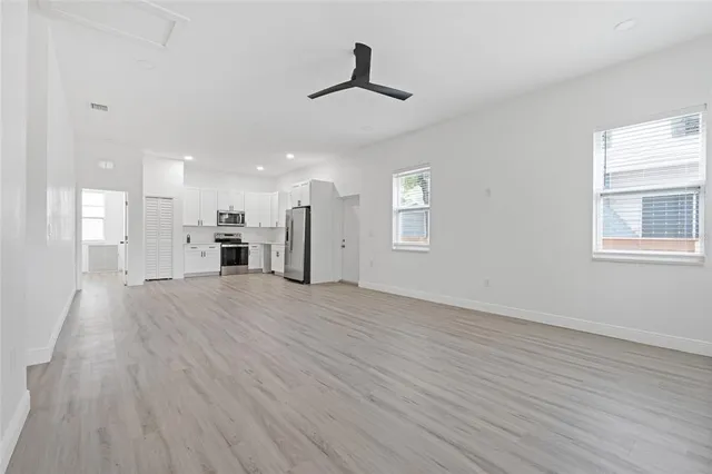 a view of empty room with wooden floor and windows