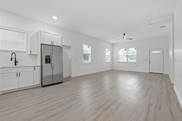 a view of a kitchen with wooden floor and a window