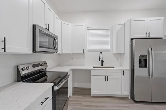 a kitchen with a refrigerator stove and sink