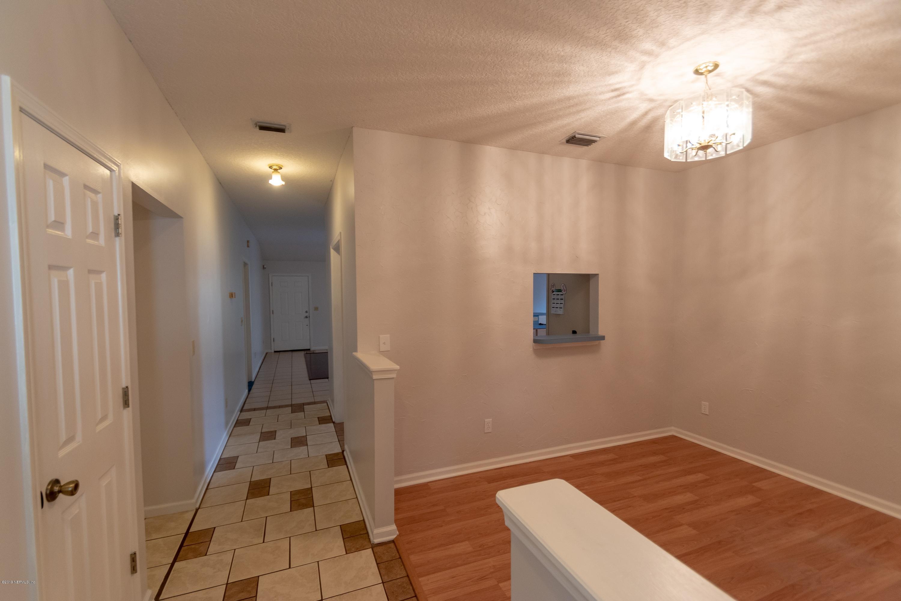 11367 Old Gainesville Road Jacksonville, FL 32221 - Photo 13 of 54 a view of a hallway with wooden floor and a chandelier