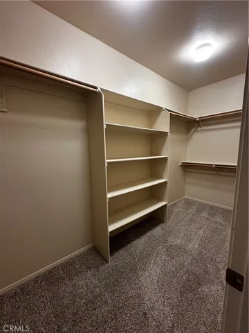 an empty room with closet and a ceiling fan
