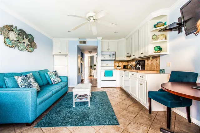 a living room with furniture and a dining table with kitchen view