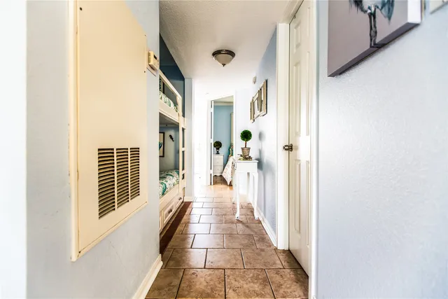 a view of a hallway with wooden floor and windows