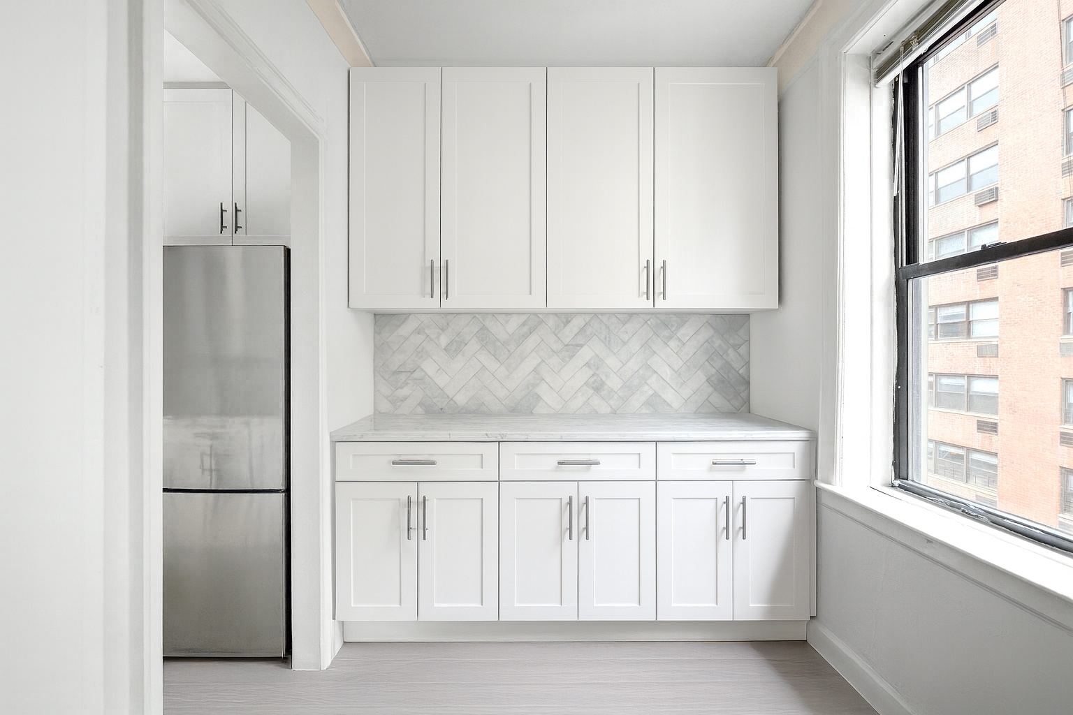 Undisclosed Address Manhattan, NY 10021 - Photo 3 of 7 a kitchen with white cabinets and a refrigerator