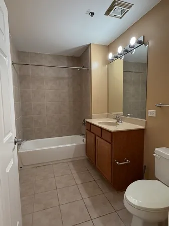 a bathroom with a bathtub shower sink vanity and toilet
