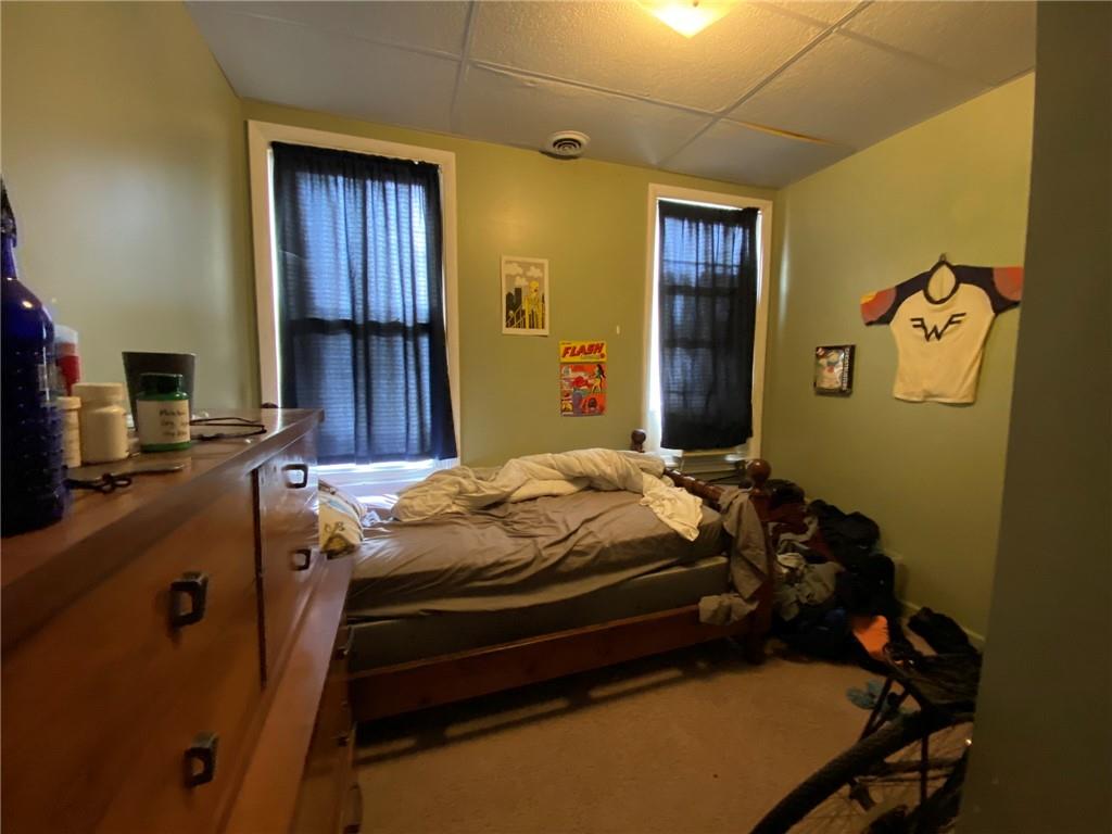 3306 Ward Street Pittsburgh, PA 15213 - Photo 8 of 12 a bed sitting in a bedroom next to a window and storage