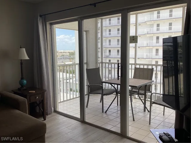 a view of a room with furniture and large windows