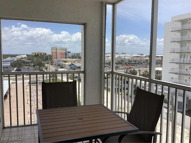 a view of a balcony with wooden floor and iron stairs