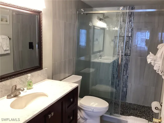 a bathroom with a sink toilet a mirror and shower