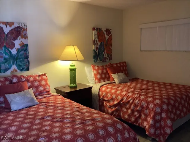 a bedroom with two beds and painting on the wall