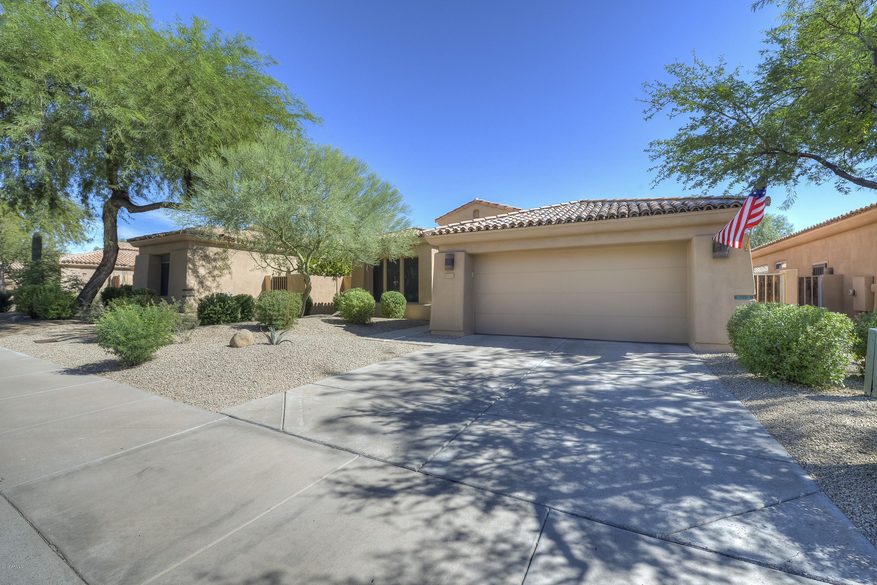 8147 East Beardsley Road Scottsdale, AZ 85255 - Photo 2 of 24 a front view of a house with a yard and garage