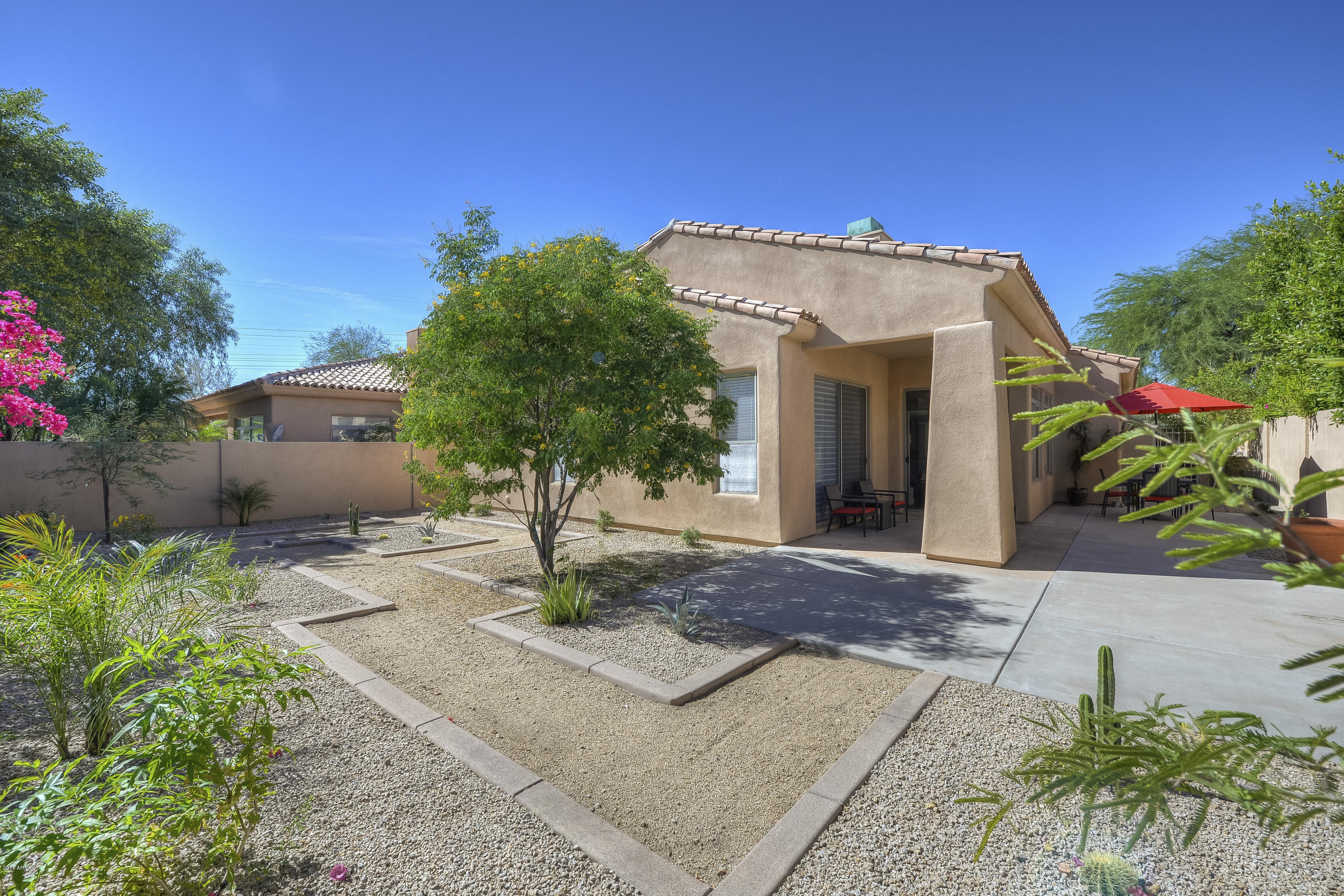 8147 East Beardsley Road Scottsdale, AZ 85255 - Photo 24 of 24 a view of a house with a small yard and potted plants