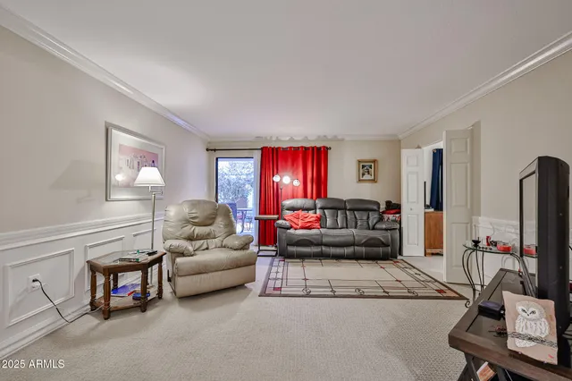 a living room with furniture a flat screen tv and a window