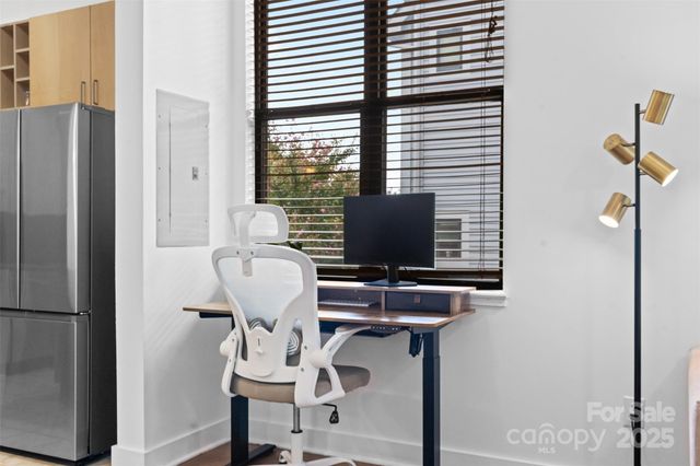 a view of workspace with wooden floor windows and refrigerator