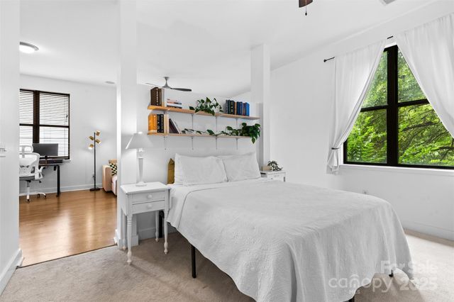 a bedroom with a bed and large windows