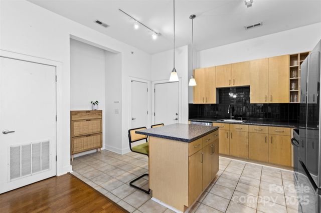 a kitchen with a sink a counter space appliances and cabinets