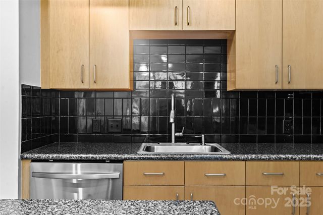 a bathroom with a granite countertop sink and white cabinets