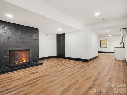 a view of empty room with wooden floor and fireplace