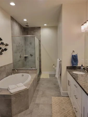 a spacious bathroom with a granite countertop tub sink and mirror
