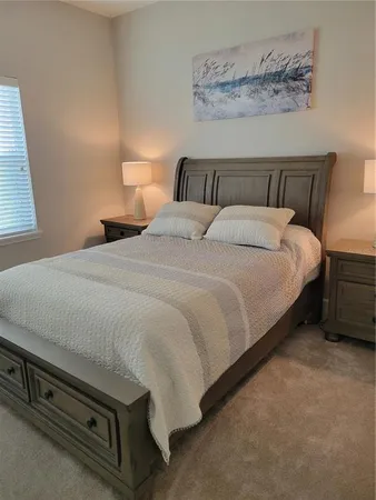 a bedroom with a bed and a night stand