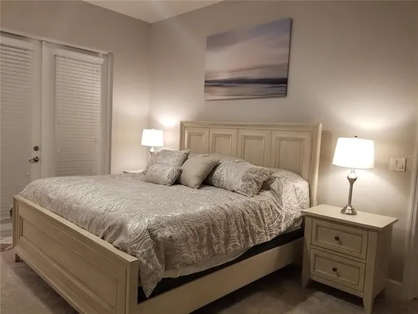 a large bed sitting in a bedroom next to a lamp