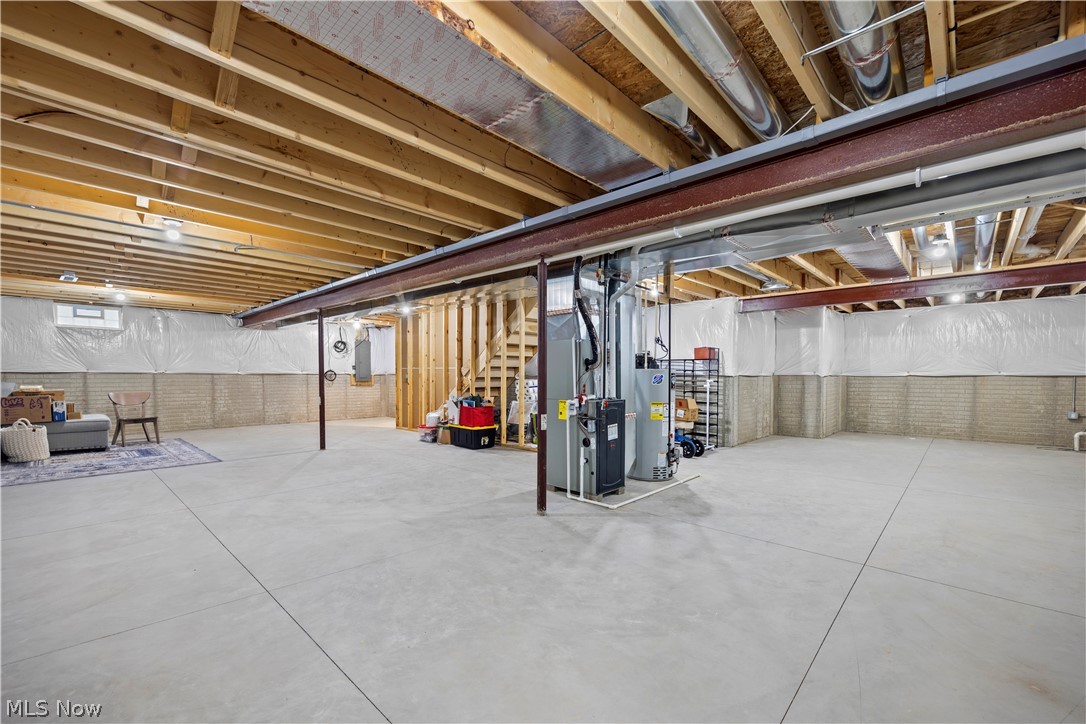 109 West Spring Drive Elyria, OH 44035 - Photo 39 of 46 Spacious unfinished basement featuring exposed ceiling joists, concrete flooring, perimeter wall insulation, and visible structural beams, offering expansion possibilities
