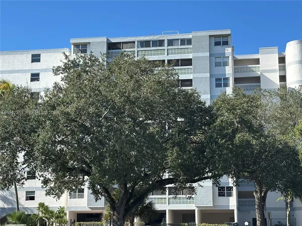 a front view of a building with a tree
