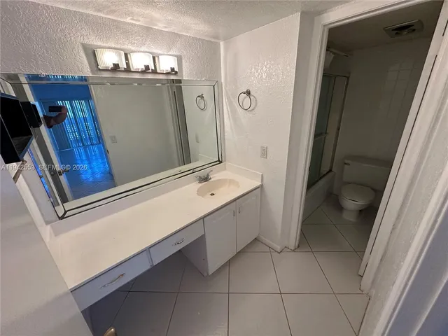 a bathroom with a sink a toilet and mirror