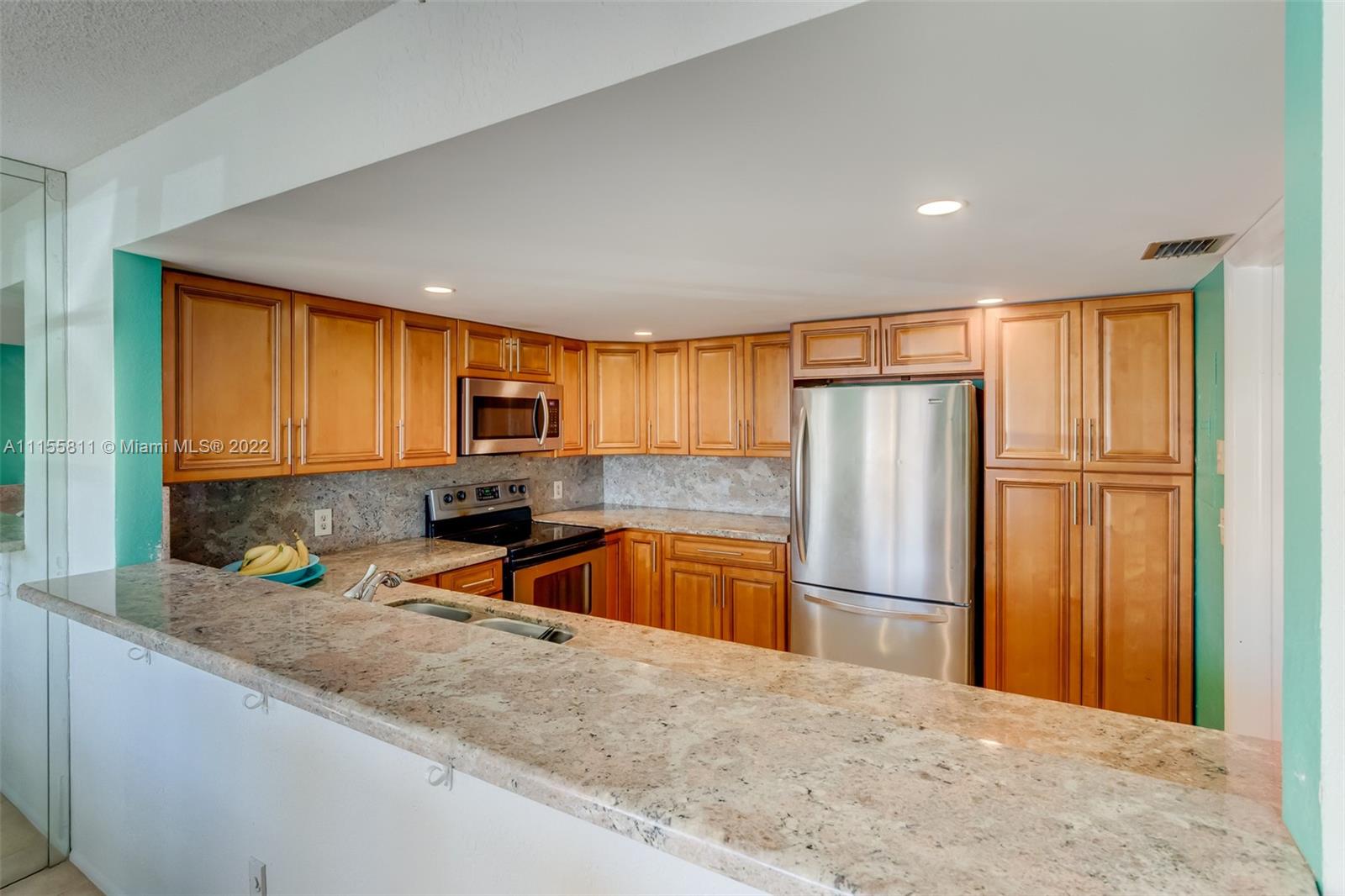 4106 Inverrary Drive, Unit 13C Lauderhill, FL 33319 - Photo 12 of 46 a kitchen with granite countertop a refrigerator and microwave
