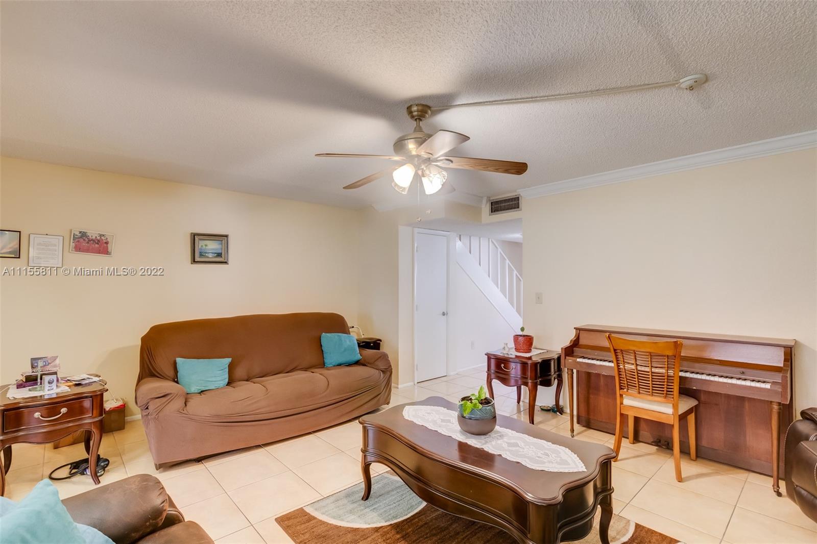 4106 Inverrary Drive, Unit 13C Lauderhill, FL 33319 - Photo 21 of 46 a living room with furniture and a chandelier