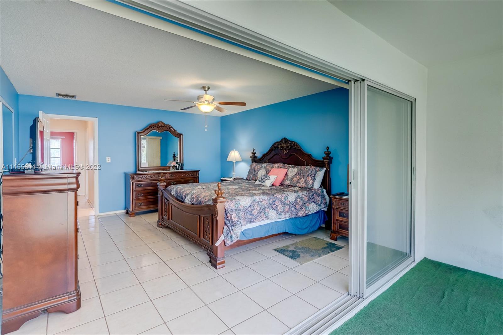 4106 Inverrary Drive, Unit 13C Lauderhill, FL 33319 - Photo 32 of 46 a bedroom with a bed and a chandelier