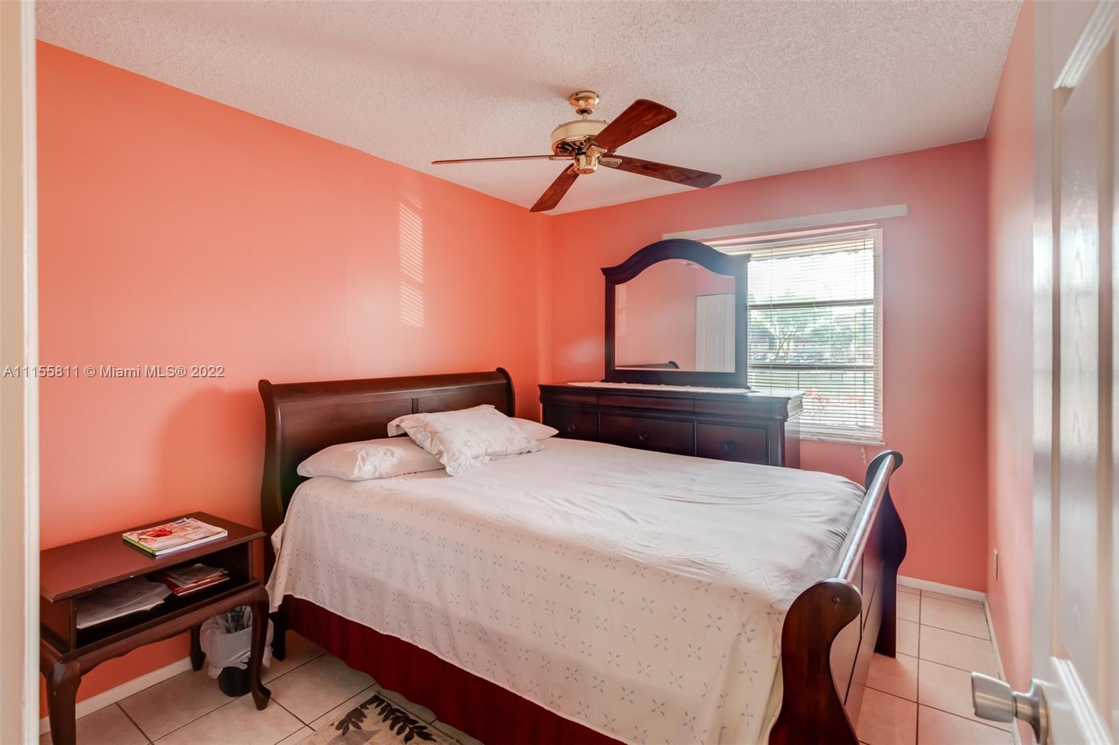 4106 Inverrary Drive, Unit 13C Lauderhill, FL 33319 - Photo 37 of 46 a bedroom with a bed and a chandelier
