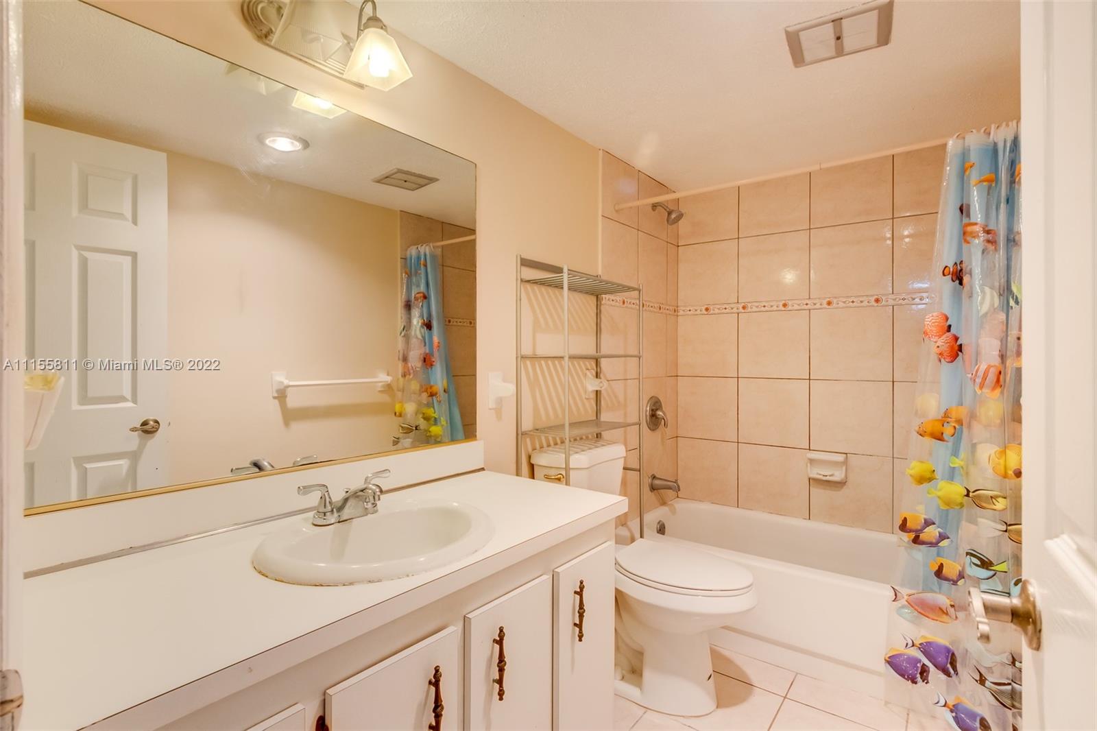 4106 Inverrary Drive, Unit 13C Lauderhill, FL 33319 - Photo 41 of 46 a bathroom with a sink a toilet and shower curtain