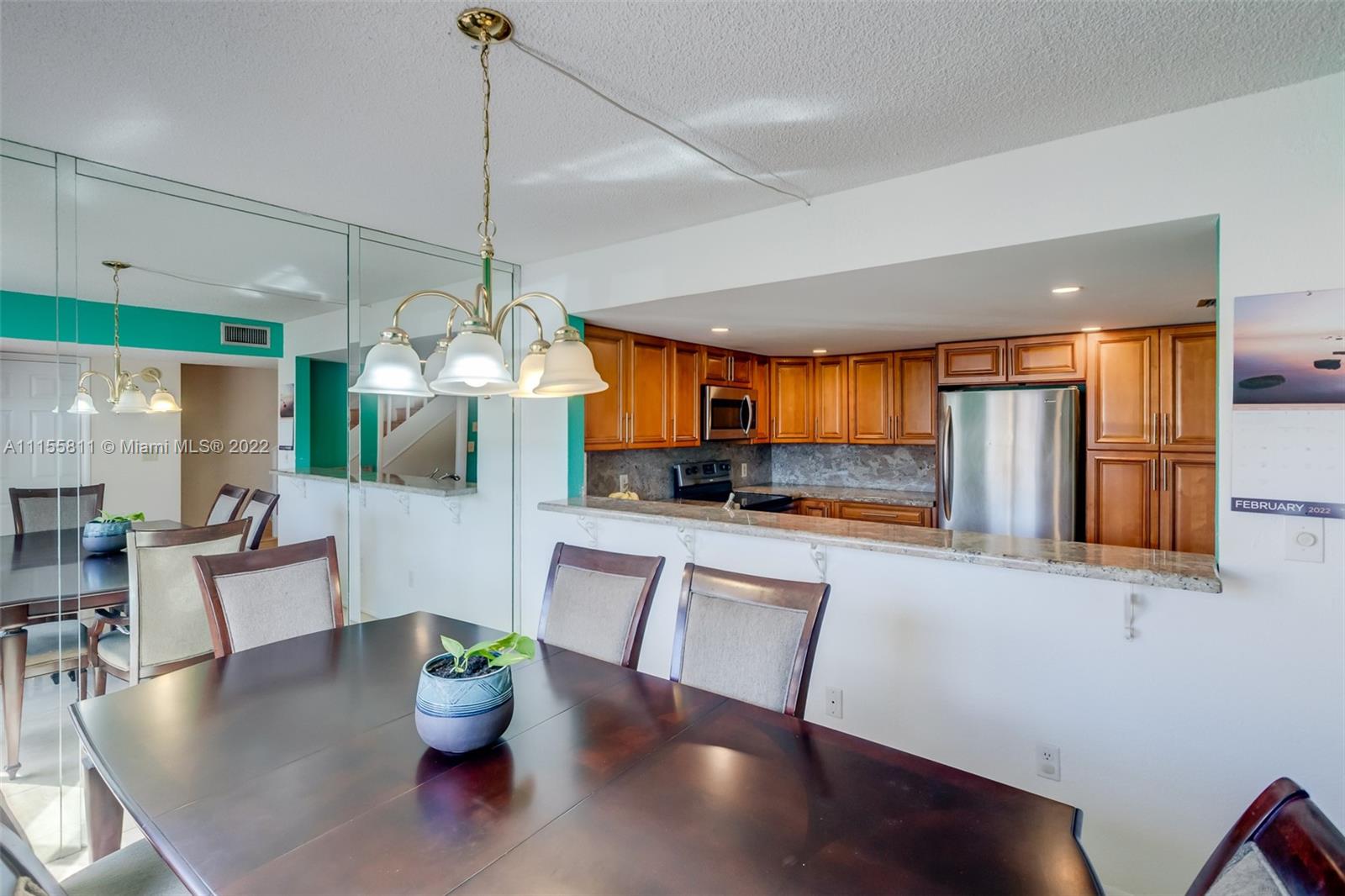 4106 Inverrary Drive, Unit 13C Lauderhill, FL 33319 - Photo 9 of 46 a kitchen with stainless steel appliances granite countertop a kitchen island a table and chairs in it