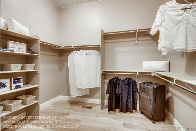 a view of walk in closet with clothes and shoes