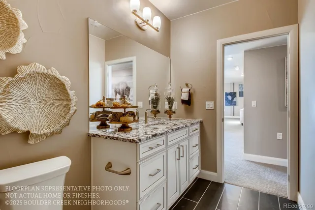 a bathroom with a granite countertop sink a toilet and mirror