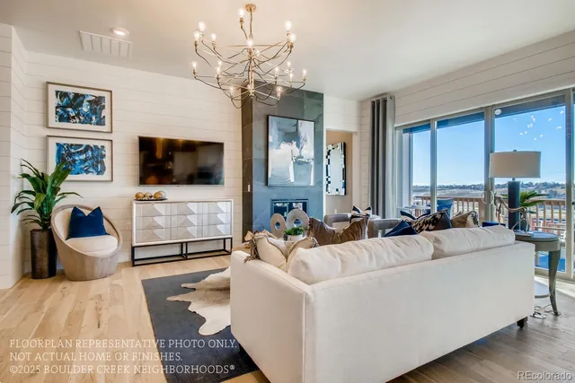 a living room with furniture a flat screen tv and a chandelier