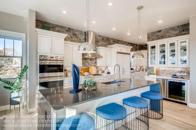 a kitchen with stainless steel appliances kitchen island granite countertop a stove and white cabinets