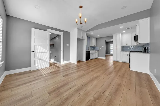 a view of a kitchen with a sink dishwasher a refrigerator and wooden floor